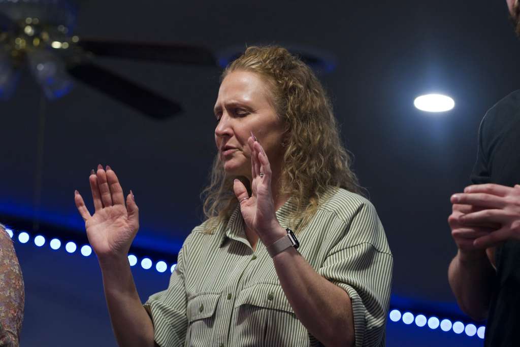 Sister worshipping with hands raised